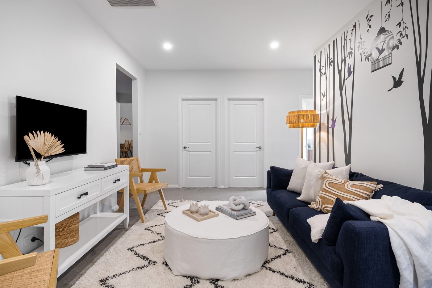 Lichte woonkamer met witte muren en een blauwe bank